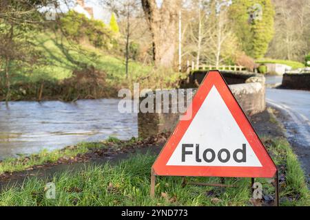 Kidderminster, Großbritannien. November 2024. UK Wetter: Nahaufnahme eines Hochwasserschildes am Fluss Stour. Der Fluss verläuft unter einer kleinen Straßenbrücke und die Straße ist nun deutlich zu sehen, da das Wasser nach dem Sturm Bert zurückgeht. Quelle: Lee Hudson/Alamy Stockfoto