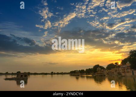 Spektakulärer Sonnenuntergang am Gadisar Lake, Jaisalmer, Rajasthan, Indien. Untergehende Sonne und bunte Wolken am Himmel mit Blick auf den Gadisar See. Vernetzter Witz Stockfoto