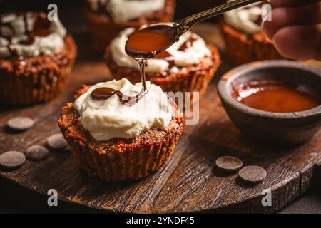 Hausgemachte glutenfreie Mandelcupcakes mit Frischkäsezuckerguss und Schokoladenganage Stockfoto
