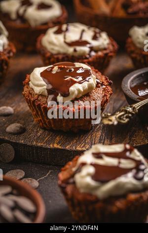 Hausgemachte glutenfreie Mandelcupcakes mit Frischkäsezuckerguss und Schokoladenganage Stockfoto