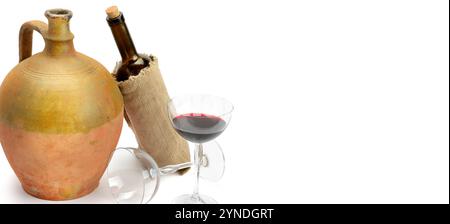 Glas mit Rotwein, eine Flasche und eine Vintage-Kanne isoliert auf weißem Hintergrund. Freier Platz für Text. Breites Foto. Stockfoto