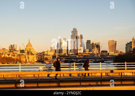 LONDON – 21. NOVEMBER 2024: Skyline der Stadt London und Arbeiter gehen über die Waterloo Bridge Stockfoto