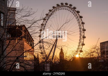 LONDON - Big Ben Houses of Parliament, Silhouetten hinter dem London Eye bei Sonnenuntergang. Stockfoto
