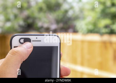 Isolierte Kamera-Schutzabdeckung Slide, Webcam-Abdeckung für Telefon mit einer Hand, die das Gerät hält Stockfoto