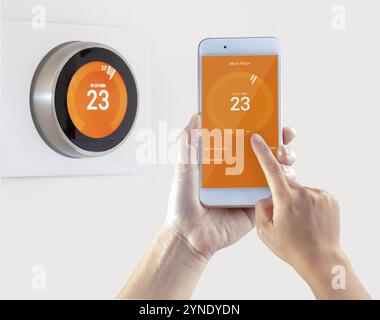 Smart Thermostat und eine Person, die Einstellung der Temperatur Smart Device hand Halten auf weißem Hintergrund Stockfoto