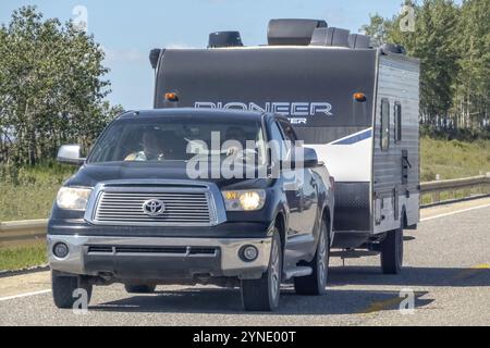 Cochrane, ab, Kanada. August 2023. Nahaufnahme eines Pickup-Trucks, der im Sommer auf einer Autobahn einen Wohnmobil zieht Stockfoto