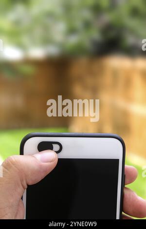 Isolierte Kamera-Schutzabdeckung Slide, Webcam-Abdeckung für Telefon mit einer Hand, die das Gerät hält Stockfoto