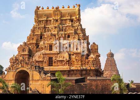 Der majestätische Eingang Gopuram von Tanjai Periya Koil mit seinen komplizierten Schnitzereien steht hoch, und der berühmte Hauptgopuram ist im Hintergrund sichtbar Stockfoto