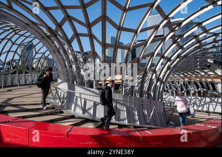 28.10.2024, Melbourne, Victoria, Australien - Menschen werden über die Webb Bridge, eine Fußgänger-/Radbrücke, die den Fluss Yarra überquert, gesehen. Stockfoto