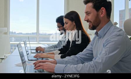 Eine Reihe von multirassischen Kundendienstmitarbeitern bietet Service mit Laptops und lächelnden professionellen Business-Team-Programmierern Geschäftsleuten und Geschäftsleuten Stockfoto