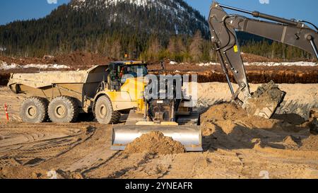 Planierschild, das Sand für die Dumper-Straße an der Ladestelle des Baggers abgibt Stockfoto