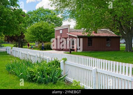 Rekonstruierte Schmiede im Stil der 1870er Jahre, hinter weißem Pflückzaun auf dem Gelände der Herbert Hoover National Historic Site — West Branch Iowa, Mai 2024 Stockfoto