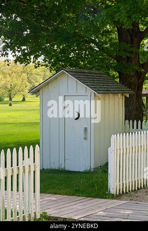 Aussichtshaus aus dem späten 19. Jahrhundert unter Laubbäumen hinter weißem Pfahlzaun Stockfoto