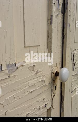 Verwitterte alte Paneeltür mit abblätternder Farbe Stockfoto