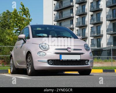 Bukarest, Rumänien – 14. August 2024: Nahaufnahme des rosafarbenen Autos Fiat 500 auf dem Parkplatz neben dem Appartementgebäude Stockfoto