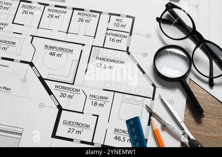 Verschiedene Architekturzeichnungen, Bleistift, Trennblätter, Lineal, Gläser und Lupe auf Holztisch, Draufsicht Stockfoto