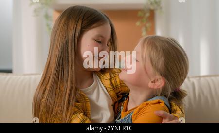 Porträt glücklich süß kleine kaukasische Mädchen Kinder Schwestern Kinder Freunde lächelnd Blick sich gegenseitig umarmen umarmen Kuschel aussehende Kamerafamilie Stockfoto