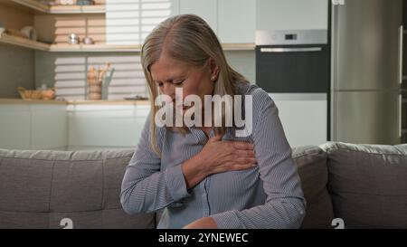 Reife ungesunde kaukasische Rentnerin Großmutter Gefühl scharfe Brustschmerzen Symptom Herzinfarkt leiden unter Herzschmerzen allein zu Hause Ältester Stockfoto