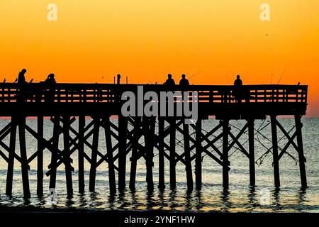 Isle Of Palms, Usa. November 2024. Fischer, die vom Sonnenaufgang umrahmt wurden, werfen ihre Linien am 25. November 2024 auf der Isle of Palms, South Carolina, ab. Quelle: Richard Ellis/Richard Ellis/Alamy Live News Stockfoto