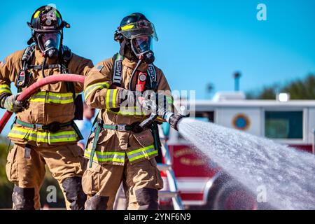 Die Feuerwehrleute der Joint Base San Antonio nehmen am 20. November 2024 an einer Live-Feuerübung in JBSA-Fort Sam Houston, Texas, Teil. Zweck der Schulung ist es, die Fähigkeit der Feuerwehr zu bewerten, einen Brand in einem Flugzeug zu löschen, während sie die Kontrolle über die Situation behält und ein Team leitet. Dies bereitet sie auf Notfälle in der Praxis vor. Während des Trainings wechselten die Mitglieder die Positionen im Trupp, um sicherzustellen, dass alle mit jeder Aufgabe vertraut waren. (Foto der U.S. Air Force von Taylor Curry) Stockfoto