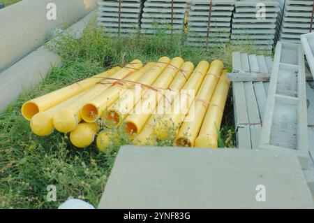 Weitsicht-Rutsche von vorgespannten Zementplanken und gelben Kunststoffrohren in einer im Bau befindlichen elektrischen Unterstation. Hochleistungsleitungen in Florida. Blau Stockfoto