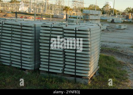 Weitsicht-Schlitten von vorgespannten Zementplanken in einem im Bau befindlichen elektrischen Umspannwerk. Hochleistungsleitungen in Florida. Blauer Himmel. Infrastruktur wird aktualisiert Stockfoto