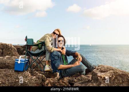 Ein Paar genießt an einem sonnigen Tag ein romantisches Picknick am Meer Stockfoto