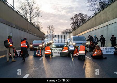 Warschau, Polen. November 2024. Die Demonstranten beginnen ihre Straßensperre während der Demonstration. (Ostatnie Pokolenie/letzte Generation) initiierte eine Reihe von Blockaden auf der Wislostrada, um die Klimapolitik der Regierung unter Donald Tusk in Frage zu stellen. Gegen 7:00 Uhr morgens blockierten ein Dutzend Aktivisten in orangefarbenen Westen den Verkehr in der Nähe des Tunneleingangs. Sie trugen Banner, darunter eines mit der Aufschrift „Tusk treibt den Klimakollaps an“. Die Gruppe kündigte eine wöchentliche Rückkehr an, um Wislostrada als Symbol für anhaltenden zivilen Widerstand zu etablieren. Quelle: SOPA Images Limited/Alamy Live News Stockfoto
