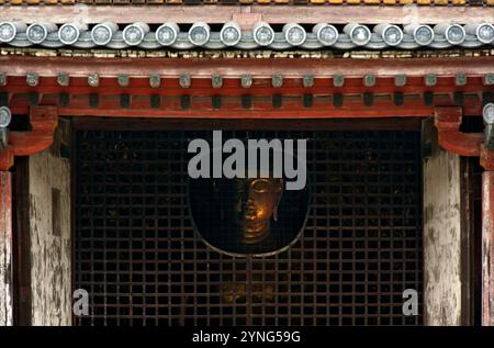 Das Gesicht der Amida-Buddha-Statue kann durch eine Öffnung im Byodo-in-Tempel in Uji, Kyoto, Japan, gesehen werden. Stockfoto