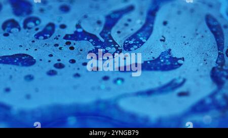 Tintenwasserfluss. Badschaum-Textur. Defokussierte blaue Farbe glänzende Glitzerpartikel Ölblase Farbe Flüssigkeit Emulsion Flüssigkeit Tropf abstrakte Kunst Hintergrund. Stockfoto