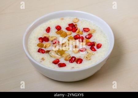 Köstliches hausgemachtes Payesh oder Payasam, serviert in einer weißen Schüssel auf hölzernem Hintergrund. Gekocht mit Milch, Zucker oder Jaggery und Reis, garniert mit Stockfoto