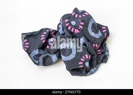 Schöne Batiktuchstücke mit Blumendrucken, isoliert auf weißem Hintergrund. Stockfoto