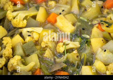 Nahaufnahme der Gemüsesorten als Hintergrund mit Blumenkohl, Karotten, Bohnen, Schlangenkürbis, Kartoffeln, Spitzkürbis und Gurken. Stockfoto