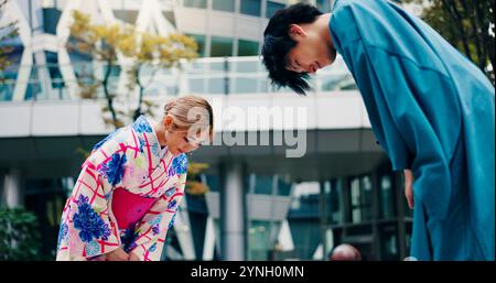 Kultur, japaner und Verbeugung um Begrüßung, Respekt und Willkommen mit Kimono in der Stadt. Traditionelle Mode, Mann und Frau mit Einführung in die Stadt Stockfoto