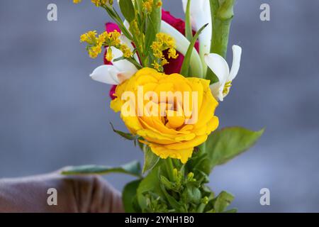 Nahaufnahme eines bunten Blumenstraußes mit gelben Rosen und duftenden weißen Tuberose-Blüten mit Knospen. Perfekt für Dekorationen, Blumensträuße oder Begrüßungen Stockfoto