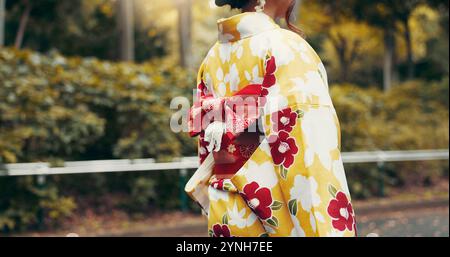 Zurück, Kimono und Spaziergang mit Japanerin im Park für Kulturerbe, Festivalzeremonie und Kultur. Traditionelle Kleidung, Mode und Respekt für asiaten Stockfoto