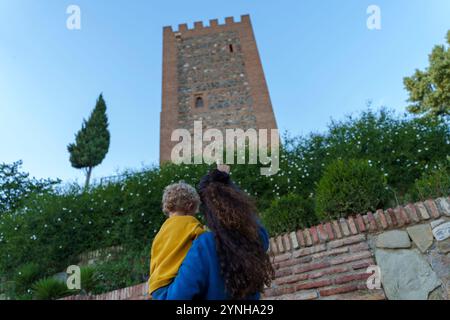 Mutter mit Kleinkind besucht eine antike muslimische Festung bei Sonnenuntergang während einer Besichtigungstour Stockfoto