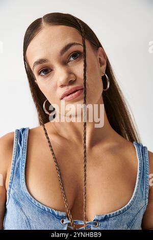 Eine junge Frau zeigt stolz ihren einzigartigen Sinn für Mode in einem stilvollen Denim-Outfit. Stockfoto