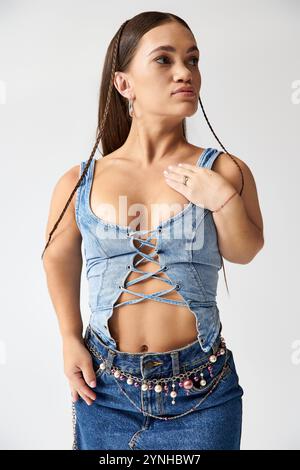 Selbstbewusste junge Frau mit Achondroplasie zeigt in einem trendigen Denim-Outfit ihren einzigartigen Sinn für Mode. Stockfoto