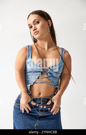 Junge Frau mit Achondroplasie in trendiger Jeansbekleidung präsentiert Mode und Vielfalt kreativ. Stockfoto