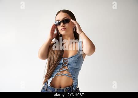 Eine junge Frau mit Achondroplasie zeigt ihren lebendigen Sinn für Mode in einem Studio-Setting. Stockfoto