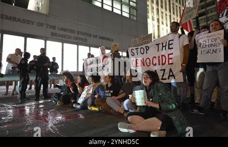 TEL AVIV, ISRAEL - 20. NOVEMBER: Israelische Friedensaktivisten halten ihre Hände in rot bemalten Händen hoch, um die in Gaza getöteten Palästinenser zu symbolisieren, während sie während einer Demonstration vor dem Büro der US-Botschaft eine Straße blockieren, die einen Waffenstillstand in Gaza fordert und die USA auffordern, Israel am 20. November 2024 in Tel Aviv, Israel zu bewaffnen. Menschenrechtsexperten haben Israel wiederholt Kriegsverbrechen in Gaza vorgeworfen, aber die Regierung Biden hat sich weitestgehend geweigert, den Waffenverkauf an Israel einzustellen. Stockfoto