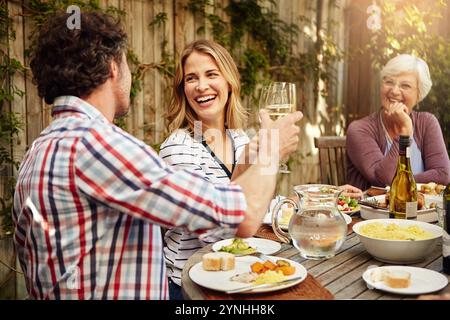 Thanksgiving, Feier und Familie mit Toast, Mittagessen zusammen und Haus Hinterhof mit Lächeln. Großmutter, Frau und Mann mit Wein im Urlaub Stockfoto