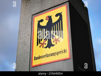 Karlsruhe, Deutschland. November 2024. Ein Schild mit dem Bundesadler und den Worten Bundesverfassungsgericht vor dem Gericht. Der erste Senat des Gerichts kündigte das Urteil über Zwangsmaßnahmen an. Nach dem Urteil ist eine Krankenhausreservierung für medizinische Zwangsmaßnahmen teilweise verfassungswidrig. Quelle: Uli Deck/dpa/Alamy Live News Stockfoto