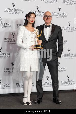 New York, USA. November 2024. Aokbab-Chutimon Chuengcharoensukying trägt Kleid von Chanel Gewinner in der Kategorie Beste Leistung einer Schauspielerin für Hunger posiert mit der Moderatorin Kelly AuCoin im Presseraum mit der Trophäe während der International Emmy Awards im Hilton Times Square Hotel in New York am 25. November 2024. (Foto: Lev Radin/SIPA USA) Credit: SIPA USA/Alamy Live News Stockfoto