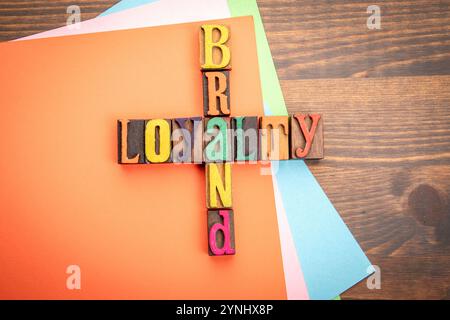 Markentreue. Wörter aus den Buchstaben des Alphabets. Kreuzworträtsel mit Holzwürfeln. Stockfoto