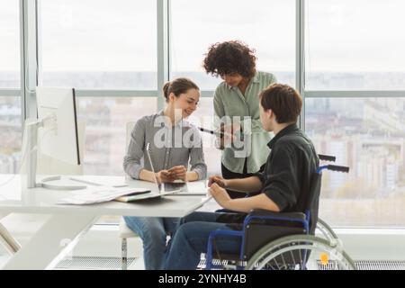 Teamwork Brainstorming. Vielfältige multirassische Kollegen Mann im Stuhl für Menschen mit Behinderungen, die zusammenarbeiten. Gruppe von Leuten, die im kreativen Büro über Geschäfte diskutieren. Junges professionelles Team Stockfoto