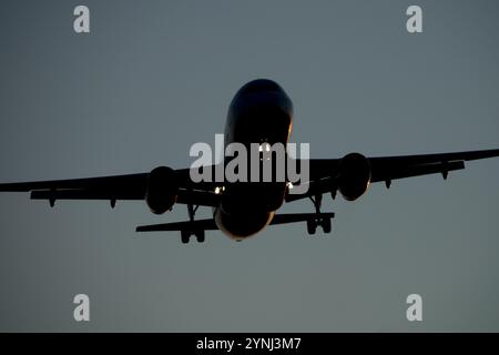 Jet-Flugzeug landet in der Abenddämmerung bei Annäherung Stockfoto