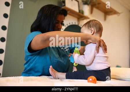 Jossigny, Frankreich. Februar 2023. Brindini Senthilkumaran, ein Osteopath in der Region Paris, führt einen Kompressionstest an der Wirbelsäule eines Säuglings durch. Brindini Senthilkumaran ist ein französischer Osteopath, der auf perinatale Pflege und Frauengesundheit spezialisiert ist. (Foto: Apolline Guillerot-Malick/SOPA Images/SIPA USA) Credit: SIPA USA/Alamy Live News Stockfoto