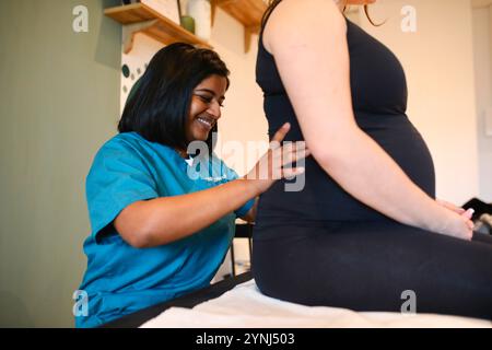 Jossigny, Frankreich. Februar 2023. Brindini Senthilkumaran, ein Osteopath in der Region Paris, führt eine Freisetzung der unteren Rückenmuskulatur bei einer schwangeren Patientin durch. Brindini Senthilkumaran ist ein französischer Osteopath, der auf perinatale Pflege und Frauengesundheit spezialisiert ist. (Foto: Apolline Guillerot-Malick/SOPA Images/SIPA USA) Credit: SIPA USA/Alamy Live News Stockfoto